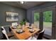 Dining room with wood table, six chairs, art, and natural light from the sliding glass doors at 1696 Hunting Creek Dr Se, Conyers, GA 30013