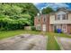 Charming townhome with a brick facade, green lawn, and a private driveway with mature trees at 1696 Hunting Creek Dr Se, Conyers, GA 30013