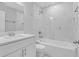 Bright bathroom features a white vanity, marble backsplash, tub with shower, and new hardware at 4806 Forest Trl, Douglasville, GA 30135