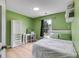 Bedroom with vibrant green walls, a large window and a bed with decorative pillows at 4905 Martin Farms Dr, Powder Springs, GA 30127