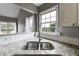 Close-up of a kitchen sink with granite countertops, subway tile backsplash, and a bright window view at 4905 Martin Farms Dr, Powder Springs, GA 30127