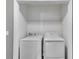 Convenient laundry closet with a white washer and dryer, featuring built-in shelving for storage at 4905 Martin Farms Dr, Powder Springs, GA 30127