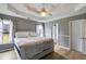This main bedroom features a tray ceiling with a fan, neutral walls, and light-colored wood floors at 4905 Martin Farms Dr, Powder Springs, GA 30127
