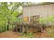 Stunning exterior view of a rustic home with a spacious deck and lush greenery surrounding the property at 5680 Whitner Dr, Atlanta, GA 30327