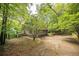 Exterior view of a charming home with a driveway surrounded by lush, mature trees offering natural beauty at 5680 Whitner Dr, Atlanta, GA 30327