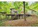 Exterior angle of a rustic home featuring a large deck, providing a picturesque view of the surrounding wooded area at 5680 Whitner Dr, Atlanta, GA 30327
