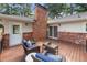 Outdoor living space featuring comfortable seating on a wooden deck with brick chimney backdrop at 839 Cardova Ne Dr, Atlanta, GA 30324