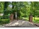 Community entrance with brick pillars, gated access and mature trees creating a lush and inviting park-like setting at 839 Cardova Ne Dr, Atlanta, GA 30324