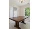 Dining room area featuring a rustic wood table, tiled floors, and natural light from the window at 3530 Boulder Cir, Ellenwood, GA 30294