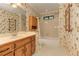Charming bathroom features a vanity, toilet, tub with shower, and colorful floral wallpaper at 4259 Arbor Club Dr, Marietta, GA 30066
