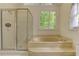 Bathroom features a glass-enclosed shower and a soaking tub beneath a window with natural light at 4259 Arbor Club Dr, Marietta, GA 30066