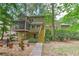 Exterior home shot from the backyard, featuring a stone pathway, stairs, and a wooded landscape at 4259 Arbor Club Dr, Marietta, GA 30066