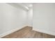 Clean basement area featuring light hardwood floors and a white painted wall at 105 Cumming St, Alpharetta, GA 30009