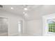 Bright bedroom with arched window, ceiling fan, neutral walls, and ensuite bath with shower at 105 Cumming St, Alpharetta, GA 30009
