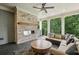 Cozy covered patio with a brick fireplace, comfortable seating, and outdoor ceiling fan at 105 Cumming St, Alpharetta, GA 30009