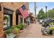 Charming street view featuring brick facade, American flag, plants, and outdoor seating at 105 Cumming St, Alpharetta, GA 30009