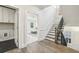 Hallway with laundry room and staircase leading to a spacious living area with ample natural light at 105 Cumming St, Alpharetta, GA 30009