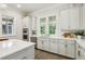 Bright kitchen with white cabinets, stainless steel appliances, and natural light from large windows at 105 Cumming St, Alpharetta, GA 30009