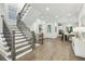Bright foyer with staircase featuring hardwood steps and iron balusters leading to the upper level at 105 Cumming St, Alpharetta, GA 30009