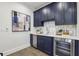 Stylish wet bar with navy cabinets, modern backsplash, quartz countertops, and stainless steel mini fridge at 105 Cumming St, Alpharetta, GA 30009