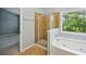 Bathroom featuring a glass shower and bathtub near a large window with natural light at 1636 Caswell Pkwy, Marietta, GA 30060