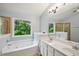Bathroom featuring double vanity sinks, separate shower, and a jetted tub with large window at 1636 Caswell Pkwy, Marietta, GA 30060