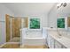 Bathroom featuring a glass shower and bathtub with jacuzzi jets near a window with natural light at 1636 Caswell Pkwy, Marietta, GA 30060
