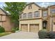 Lovely brick townhome featuring a two-car garage, front entrance, and mature landscaping at 1636 Caswell Pkwy, Marietta, GA 30060