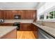 A well-equipped kitchen featuring wood cabinets, granite counters, a cooktop, and stainless steel appliances at 2988 Rivergreen Se Ln, Atlanta, GA 30339