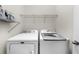 Well-lit laundry room features a side-by-side washer and dryer with wire shelf at 2988 Rivergreen Se Ln, Atlanta, GA 30339