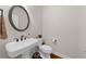 Elegant powder room features a pedestal sink, decorative mirror, and hardwood flooring at 2988 Rivergreen Se Ln, Atlanta, GA 30339