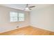 Bright bedroom with gleaming hardwood floors, a modern ceiling fan, and a large window at 4140 Candler Lake West Ne, Atlanta, GA 30319