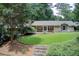 Well-maintained home with a large front yard, mature trees, and a covered porch at 4140 Candler Lake West Ne, Atlanta, GA 30319