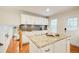 Open kitchen with center island, granite countertops, and white cabinets, adjacent to dining area at 4140 Candler Lake West Ne, Atlanta, GA 30319