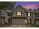 Charming two-story townhouse showcasing a brick facade and attached garage against a colorful twilight sky at 461 Mountain View Ln, Woodstock, GA 30188