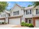 Inviting townhome with gray siding, brick details, a two-car garage, and a welcoming front porch at 461 Mountain View Ln, Woodstock, GA 30188