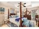 Spacious main bedroom featuring a four-poster bed, ceiling fan, and windows, creating a luxurious retreat at 461 Mountain View Ln, Woodstock, GA 30188