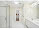 An airy white bathroom featuring double sinks, glass shower, and walk-in closet at 718 Surrey Park Se Pl, Smyrna, GA 30082