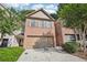 Inviting brick townhome featuring a spacious two-car garage and landscaped front yard at 718 Surrey Park Se Pl, Smyrna, GA 30082