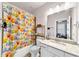 Bathroom with light granite countertops, white cabinetry and a shower with a colorful dog-themed curtain at , Kennesaw, GA 30152