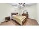 Bedroom featuring laminate floors, ceiling fan, decorative wall art, and rustic wooden bedroom furniture at , Kennesaw, GA 30152
