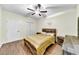 Bedroom featuring laminate floors, ceiling fan, decorative wall art, and rustic wooden bedroom furniture at , Kennesaw, GA 30152
