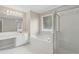 Bright bathroom featuring a soaking tub, tiled floor, a glass shower, and a vanity with ample lighting at 1250 Parkview Nw Ln, Kennesaw, GA 30152
