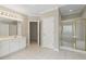 Clean bathroom features a tub with a glass enclosure, tile floors, and ample counter space with bright lighting at 1250 Parkview Nw Ln, Kennesaw, GA 30152