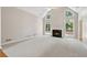 Open-concept living room featuring a fireplace, large windows, and plush carpet at 1250 Parkview Nw Ln, Kennesaw, GA 30152