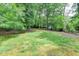Backyard featuring green grass and mature trees at 1592 Walkway Ct, Lilburn, GA 30047