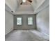 Spacious bedroom featuring a tray ceiling with fan, two windows, and plush carpeting at 1592 Walkway Ct, Lilburn, GA 30047