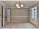 Bright dining room featuring chair rail, chandelier lighting, and a large window for natural light at 1592 Walkway Ct, Lilburn, GA 30047