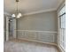 Dining room with chair rail, neutral paint, two windows, and an elegant chandelier at 1592 Walkway Ct, Lilburn, GA 30047