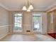 Open dining area with two large windows, chair rail molding, and entryways to other rooms at 1592 Walkway Ct, Lilburn, GA 30047